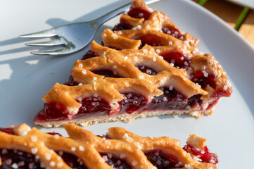 Homemade open sour cherry pie, delicious sweet dessert served in pieces outdoor in garden
