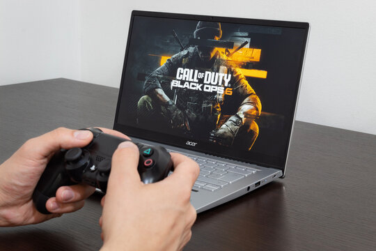 Close up to a male hands holding a play station controller playing call of duty black ops six on a modern acer laptop