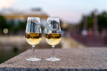 Sherry wine tasting on roof of old Triana district in Sevilla with view on Sevilla houses and river, wine glasses
