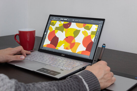 Close up to a adobe illustrator graphic designer program interface into an acer laptop with a wacom pen tablet 