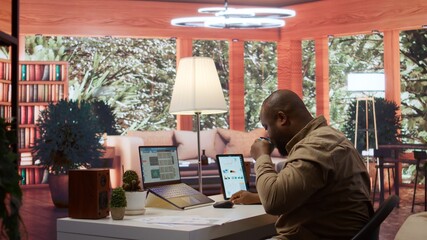 Entrepreneur falling asleep while he is calculating the annual sales reports to review the budget, feeling exhausted and fatigued working from home. Businessman with burnout. Camera B.