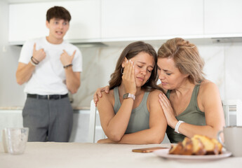 Mom calms her daughter down during a domestic quarrel with her young husband