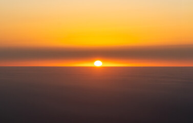 Obraz premium Golden Horizon: A serene sunset over a sea of clouds