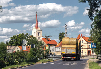 Summer cityscape of Nowe Miasteczko, Nowa S&oacute;l County, Lubusz (lubuskie). Agriculture: harvest season. Straw rolls in the trailer pulled by tractor.