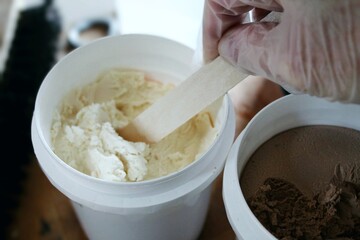 a person using a wooden stick in wood putty for restoration with gloved hand. home improvement design element