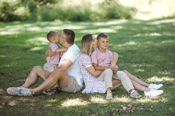 Fototapeta premium Kiss delivery for dad and mom. Cropped shot of a young family spending time together outdoors.