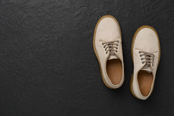 Beige suede shoes on concrete background, top view