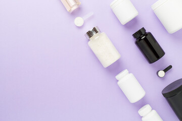 Jars with protein powder on color background, top view. Sports nutrition concept