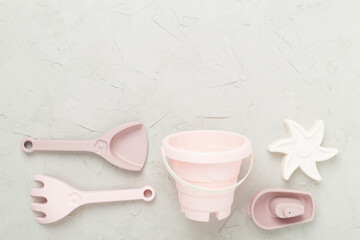 Cute toys for playing with sand on concrete background, top view