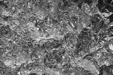 Processed collage of shiny metal silver gray foil crumpled packaging material texture