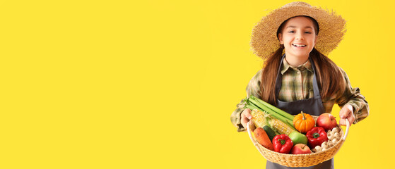 Little farmer with fresh food on yellow background