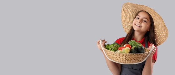 Little farmer with fresh food on light background