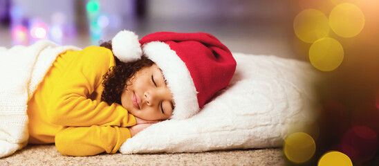 New Year night. Little afro girl in Santa hat napping on floor, panorama