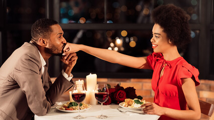 Loving African American Boyfriend Kissing Girlfriend's Hand Dating Celebrating Valentine's Day In Restaurant. Panorama