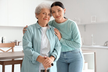 Senior woman with her daughter hugging in kitchen