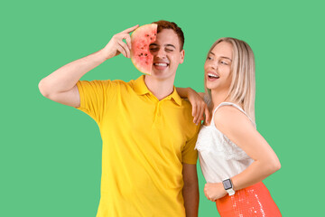 Fototapeta premium Young beautiful man and woman with slice of fresh watermelon on green background
