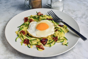 zucchini noodles  with a fried egg and bacn
