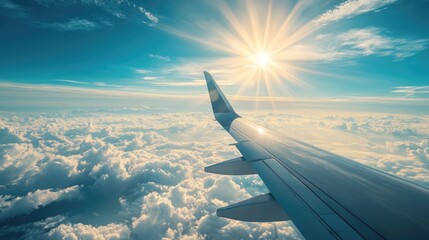 Obraz premium Beautiful aerial view from an airplane, soaring above the clouds with a breathtaking view of a bright blue sky and vibrant sun rays