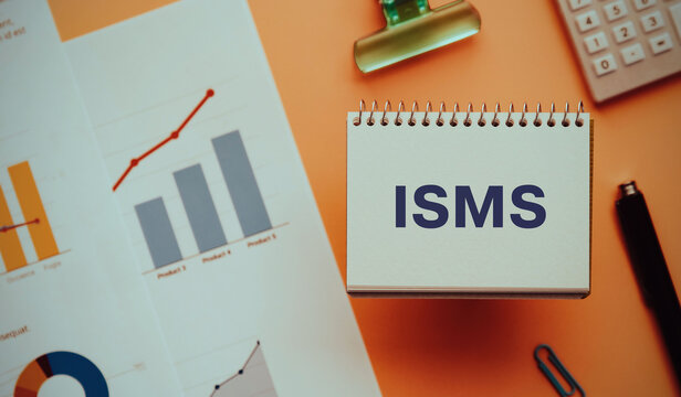 There is notebook with the word ISMS. It is an abbreviation for Information Security Management System as eye-catching image.