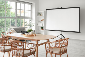 Interior of light room with projector screen and dining table