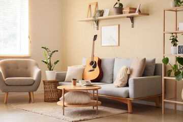 Interior of living room with sofa, armchair and green plants