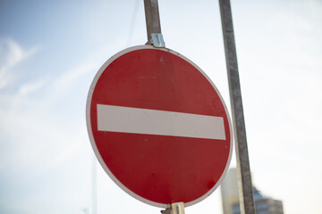 No entry road sign under blue sky.
