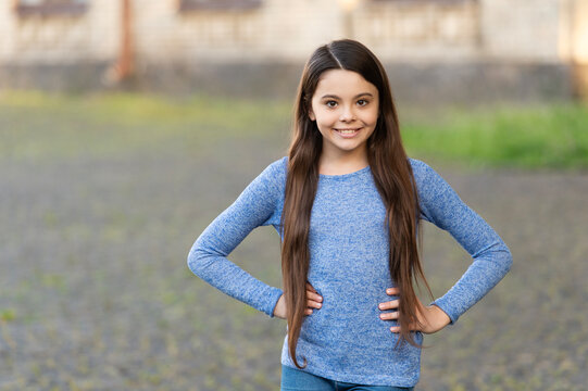 Autumn fashion girl. Trendy and stylish teenager girl smiling. Fall fashion style for teen. Complete outfit style. Girl portrait in casual sweater. Copy space. Teen girl with long hair outdoor