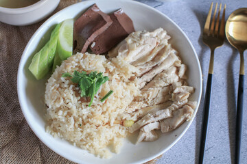 Rice steamed with chicken soup and dipping sauce or Khao Mun Kai in white plate. thai food concept.