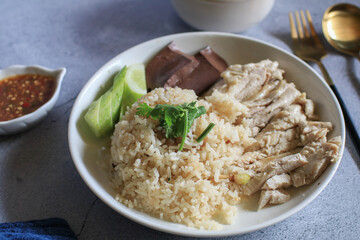 Rice steamed with chicken soup and dipping sauce or Khao Mun Kai in white plate. thai food concept.
