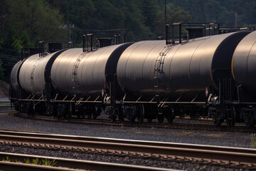 Black tank cars cisterns for gas and oil, captured in Portland, Oregon industrial area. High quality close up picture for download.