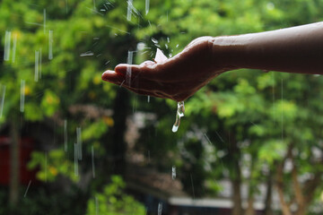 hand with splashes of falling rainwater. falling rainwater hits hand	