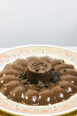 Chocolate pudding on white plate with woven tablecloth isolated