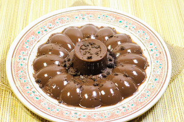 Chocolate pudding on white plate with woven tablecloth isolated