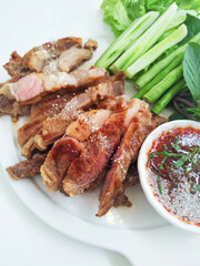 Sliced ​​grilled beef and vegetables with Thai spicy sauce served on a plate. Food menu.