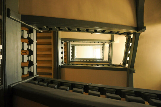 Symmetrical old spiral staircase with warm lighting and intricate details