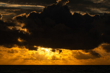 The sun's rays shine through the clouds, creating beautiful images above sea level.Beautiful, colorful, sunrise over the sea