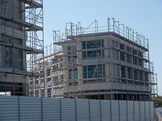 New apartments under construction. Close up on new apartment building with scaffolding around the exterior.