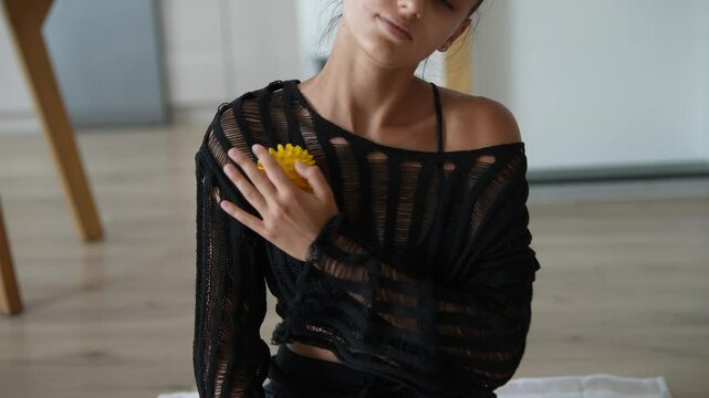 A person in a meditative pose is surrounded by a spiky yellow object in a holistic setting