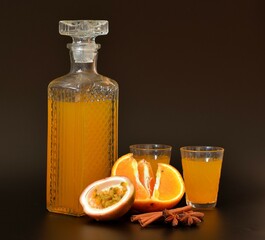 Orange liqueur with added passion fruit, cinnamon and anise in a crystal decanter and two shot...
