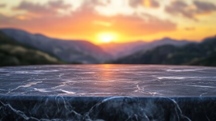 Fototapeta premium A marble table in the foreground with a sunset over mountains in the background.