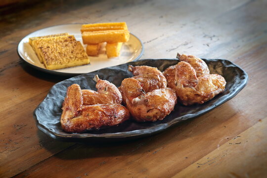 pieces of roast chicken, known in Brazil as galeto, on a plate with fried polenta