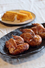 pieces of roast chicken, known in Brazil as galeto, on a plate with fried polenta
