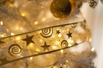 cinta decorativa de estrellas en árbol de navidad blanco artificial con esfera brillante dorada