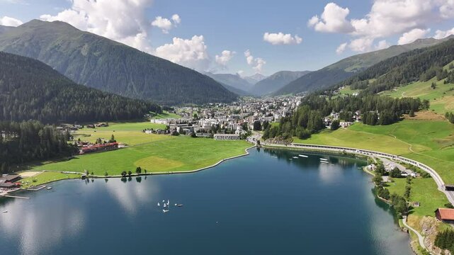 Lake Davos And Townscape Surrounded By Mountains In Canton Of Graubunden, Switzerland. aerial panning shot