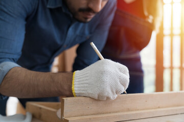 Hands of carpenter working and building furniture at wood workshop