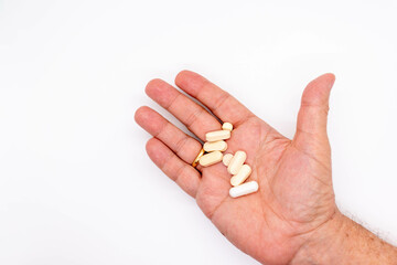 Hand of an elderly person holding some medicinal and vitamin pills medicine concept, selective focus, copy space
