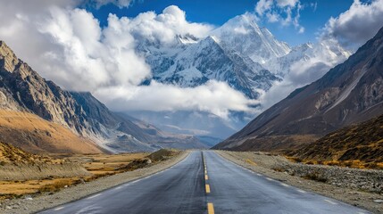 Fototapeta premium Cloud-draped Passu Cones overlooking the Karakoram Highway, a paved road winding through the peaceful valley of Gojal, surrounded by nature's beauty.