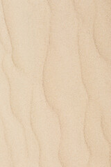 Detail of fine sand texture with natural wave patterns, showing the smooth, grainy surface of a desert dune.