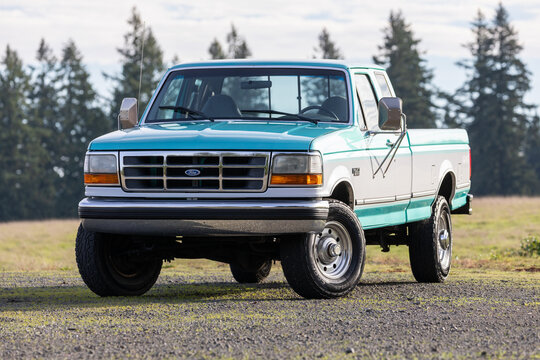 Portland, OR, USA - Dec 13, 2023 - 1994 Blue White Ford F-250 XLT  pickup truck American 4X4 SUV off-road vehicle exterior. High quality picture for download.