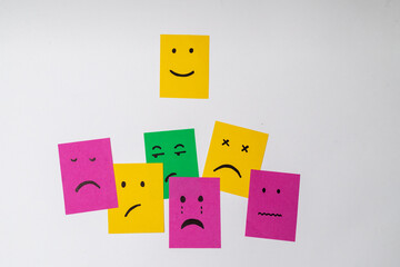 Mixed smileys of different emotions on sticky notes and smile sticky note stand out as a concept of happiness, white background